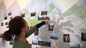 Zoe Childerley in her studio pointing at the map of her walk